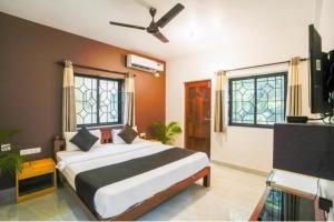 a bedroom with a large bed with a ceiling fan at Pasquina guest house in Calangute