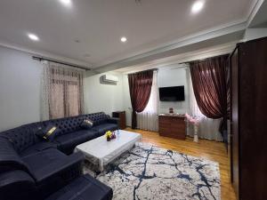 a living room with a couch and a table at Shuxrat hotel in Chilanzar +24 photos