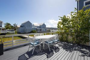 a patio with a table and chairs on a deck at Amanzi on Thesen Island - Knysna in Knysna