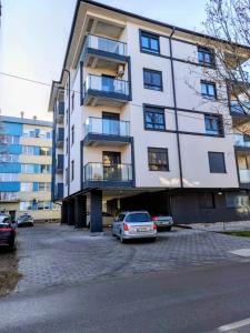 a white building with cars parked in front of it at Apartman Kladovo in Kladovo