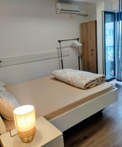 a bedroom with a bed and a lamp on a table at Apartman Kladovo in Kladovo