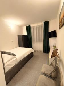 a hotel room with a bed and a chair at Dumbravii House in Sibiu