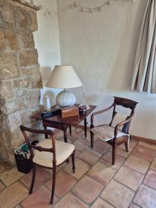 a table with two chairs and a lamp on a table at La Ruchanne in Tourrettes-sur-Loup