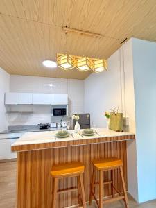 a kitchen with a counter and two stools at a bar at Montara villa Chaloklum Koh phangan in Chaloklum