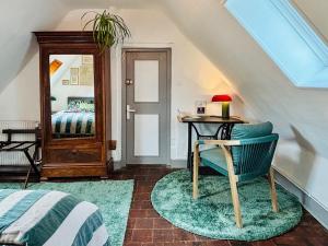a room with a chair and a table with a mirror at La Ferme de Montreuil in Montreuil-lʼArgillé