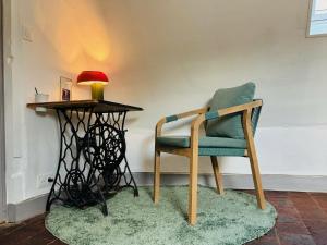 a chair sitting next to a table with a lamp at La Ferme de Montreuil in Montreuil-lʼArgillé +12 photos