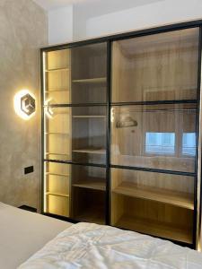 a bedroom with a glass closet with a bed at Aura Apartament Oberhausen in Oberhausen