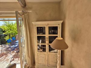 a china cabinet with a lamp in a living room at La Ruchanne in Tourrettes-sur-Loup +14 photos