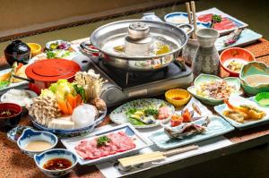 a table topped with plates of food and a pot of food at Yaki no Yu - Vacation STAY 29804v in Takayama