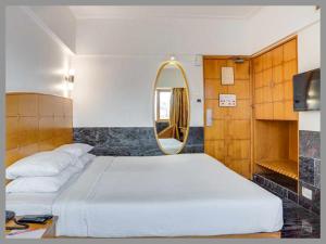 a bedroom with a large bed and a mirror at Hotel - RD DIVINE - Near Shree Kashi Vishwanath Temple - Free Wi-Fi & Fully Air Conditioning Hotel In Pricious Location In Varanasi in Rāmnagar