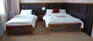 two twin beds in a room with two tables at Hotel Himalayan vista in Pāti Bhanjyāng