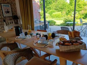 a wooden table with bread and pastries on it at Côté Poules 