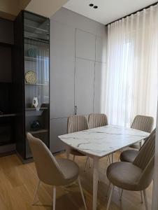 a dining room with a white table and chairs at Luxury Apartment Yunusabad Residence - US Embassy in Yunusobod