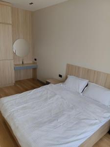 a large white bed in a bedroom with a lamp at Luxury Apartment Yunusabad Residence - US Embassy in Yunusobod