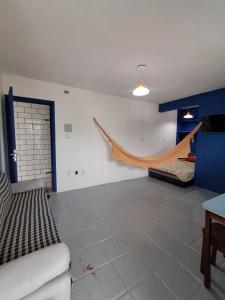 een woonkamer met een hangmat aan de muur bij Apartamento completo Jacumã in Conde