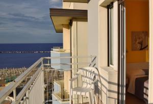 a balcony with two white chairs and the ocean at Hotel Graziella in Bellaria-Igea Marina