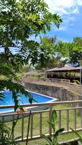 una piscina junto a una valla y un edificio en Lutaw Farm Pool and Villas, en General Luna