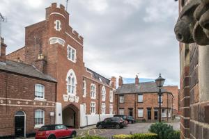 a large brick building with cars parked in front of it at The Penthouses, 9 Albion Mews in Chester