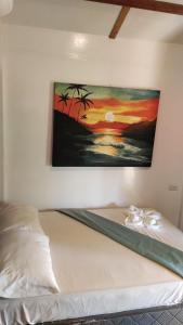 a painting hanging on a wall above a bed at Lutaw Farm Pool and Villas in General Luna
