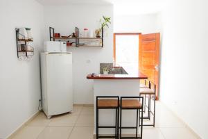 a kitchen with a counter and a refrigerator at Loft Barra dos pescadores in Ubatuba