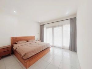 a bedroom with a bed and a large window at Sonteng homestay in Sengkol