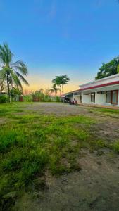 a building with a grass field in front of a building at Sonteng homestay in Sengkol
