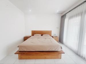 a bedroom with a bed and a large window at Sonteng homestay in Sengkol +5 photos