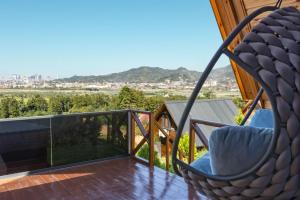 einen Schaukelstuhl auf einem Balkon mit Aussicht in der Unterkunft Via Bungalows Batumi in Batumi