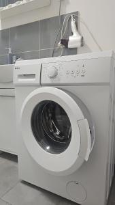 a white washing machine sitting in a room at Home comfort in the heart of the city in Piotrków Trybunalski