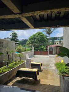 a patio with a bench and a table and a chair at Casa Tolentino Tagaytay - Full house in Tagaytay +25 photos