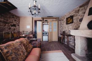 a living room with a couch and a kitchen at Casa dos Candeias - Apartamento Tio João in Chaves