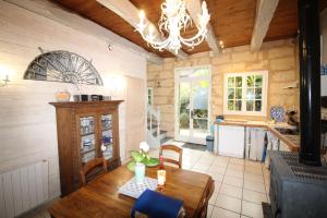 a kitchen with a wooden table and a chandelier at le gîte de Claire maison avec terrasse, calme et confort, lit king size linge fourni in Couze-et-Saint-Front