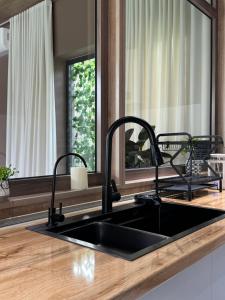 eine Küchenspüle mit zwei Armaturen und einem Spiegel in der Unterkunft Micasa residence in Schymkent + 17 Fotos