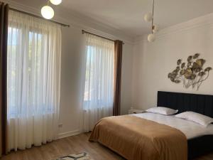 ein Schlafzimmer mit einem Bett und einem großen Fenster in der Unterkunft ARIS ULTRACENTRAL APARTAMENT 2 camere PIATA UNIRII in Iaşi