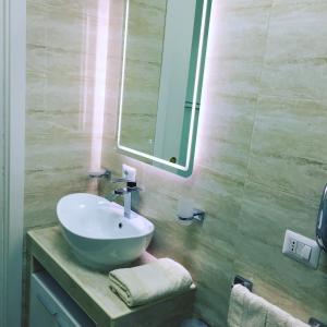 uma casa de banho com um lavatório e um espelho em B&B Quintino Sella em Iglesias
