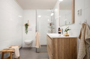 Un baño con inodoro, lavabo y ducha. en Large 3 bedroom apartment in the center with parking, en Vossevangen