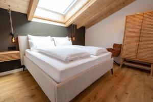 a large white bed in a room with a window at Das Sonneneck Appartements in Grainau +63 photos