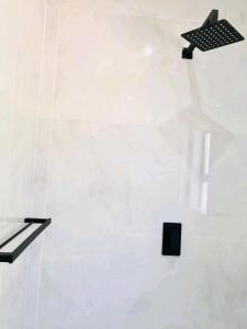 a white wall with three black objects on it at Atoma Lodge in Shakawe +2 photos