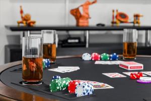 a table with poker chips and two glasses of beer at Spacious 6BR Getaway Game Room Firepit NYC in Elmsford