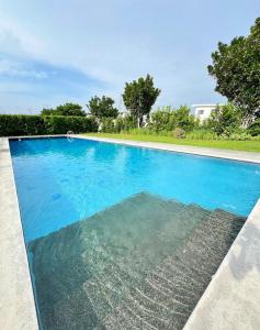 a large swimming pool with blue water at H&K Partner Guest House 