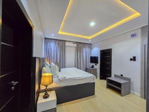 a bedroom with a bed and a room with a lamp at Twinny properties in Lagos