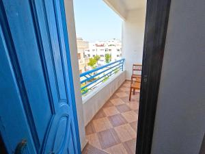 Una puerta azul que da a un balcón con vista. en Martil Apartment Near Beachfront, en Martil 5 fotos más