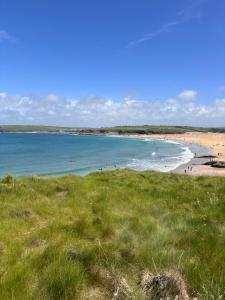 a view of a beach with people in the water at Tigh na Mara in Padstow