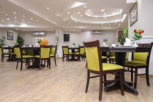 ein Esszimmer mit Tischen und gelben Stühlen in der Unterkunft Gawharet Al Ahram Hotel in Kairo