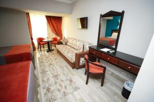 ein Wohnzimmer mit Sofa und Spiegel in der Unterkunft Gawharet Al Ahram Hotel in Kairo