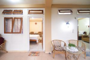 a room with a table and chairs and a bedroom at Natalia Homestay Ruteng in Ruteng