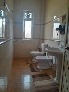a bathroom with two toilets and a sink and a window at Yoga Guesthouse in Shkodër