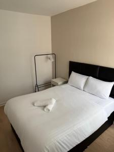 een wit bed met een zwart hoofdeinde en witte kussens bij Two bedroom house free parking in Liverpool