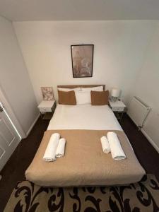 ブレントフォードにあるStylish 4BR House with Garden and Free Parking in Ealingの大きなベッドとタオル2枚のある寝室