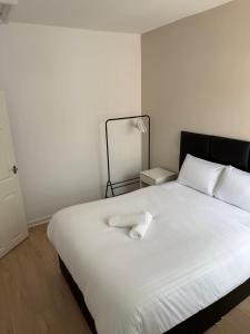 een wit bed met een witte handdoek erop bij Two bedroom house free parking in Liverpool